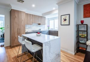 a kitchen with a white countertop and stools