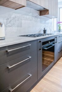 a kitchen with grey cabinets and white counter tops