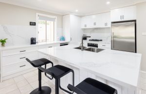 a white kitchen with black stools