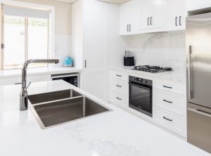 a kitchen with white cabinets and a sink
