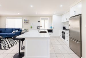 a kitchen with a white island and a blue couch