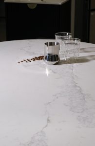 a coffee beans and a silver pitcher on a white table