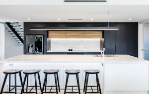 a kitchen with stools and a bar