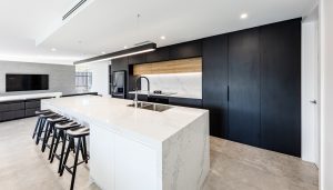 a kitchen with a white countertop and black cabinets