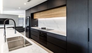 a kitchen with black cabinets and a white countertop