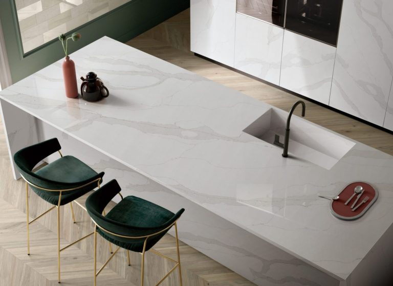 a white counter top with green chairs and a black sink