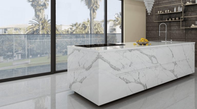 a white marble island in a room with large windows