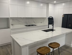 a white kitchen with a marble island