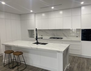 a white kitchen with a black faucet