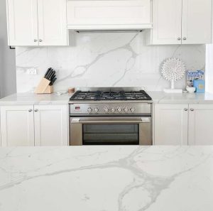 a kitchen with white cabinets and a stove