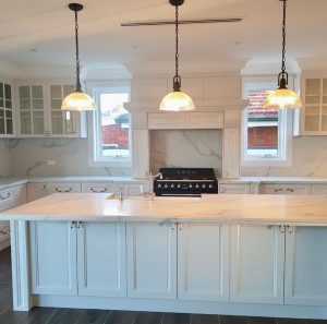 a kitchen with white cabinets and lights