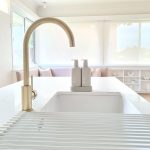 a sink with a faucet and a gold faucet