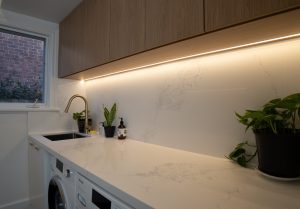 a white counter top with a sink and a washing machine