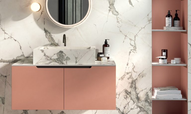 a bathroom with pink cabinets and a round mirror