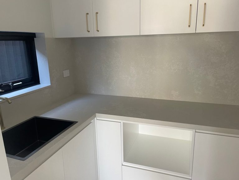 a white kitchen with a black sink and a window