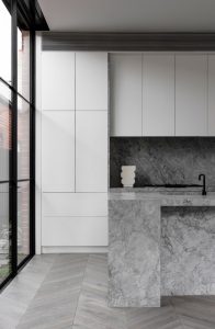 a kitchen with marble countertop and a glass door