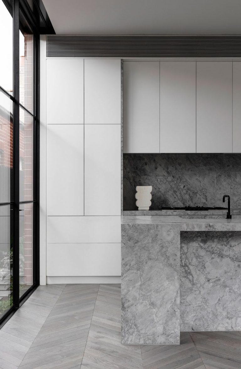 a kitchen with marble countertop and a glass door