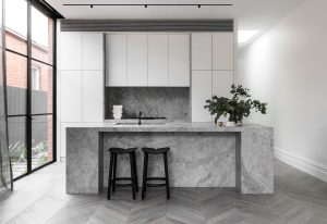 a kitchen with a marble countertop and stools
