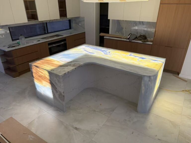 Blue Crystal quartzite translucent kitchen island in Sydney, L-shaped design with backlit lighting highlighting natural stone patterns, custom fabrication by AUSKstone.